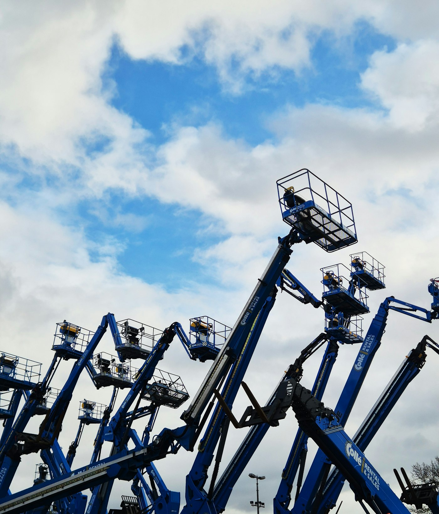 Rows of boom lifts in an equipment rental yard
